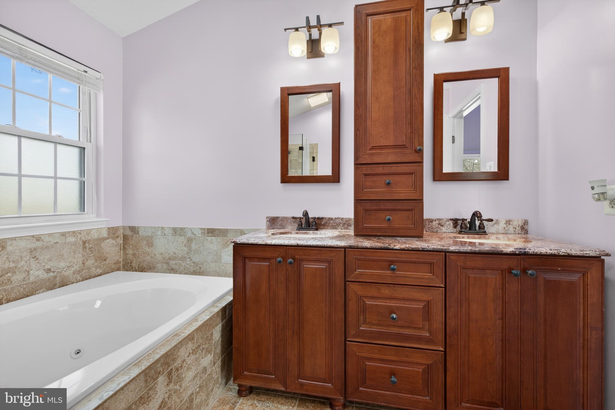 611 Hunting Ridge Drive Frederick, MD 21703 - Photo 40 of 50 a bathroom with a tub sink and mirror