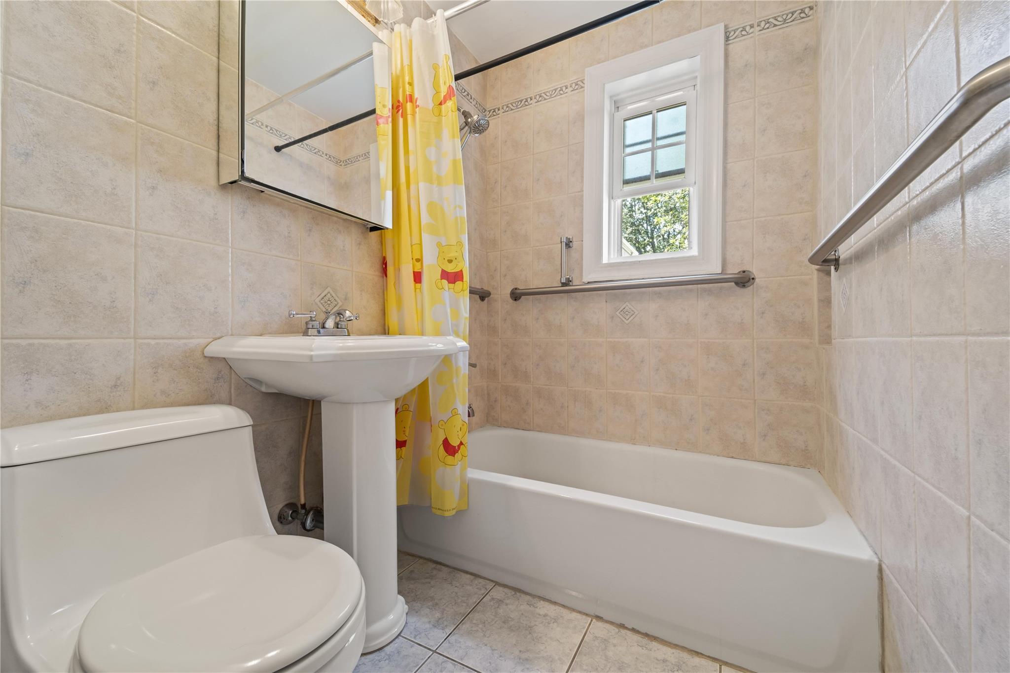 221-03 67th Avenue, Unit 1 Queens, NY 11364 - Photo 12 of 14 a bathroom with a sink a toilet and bathtub