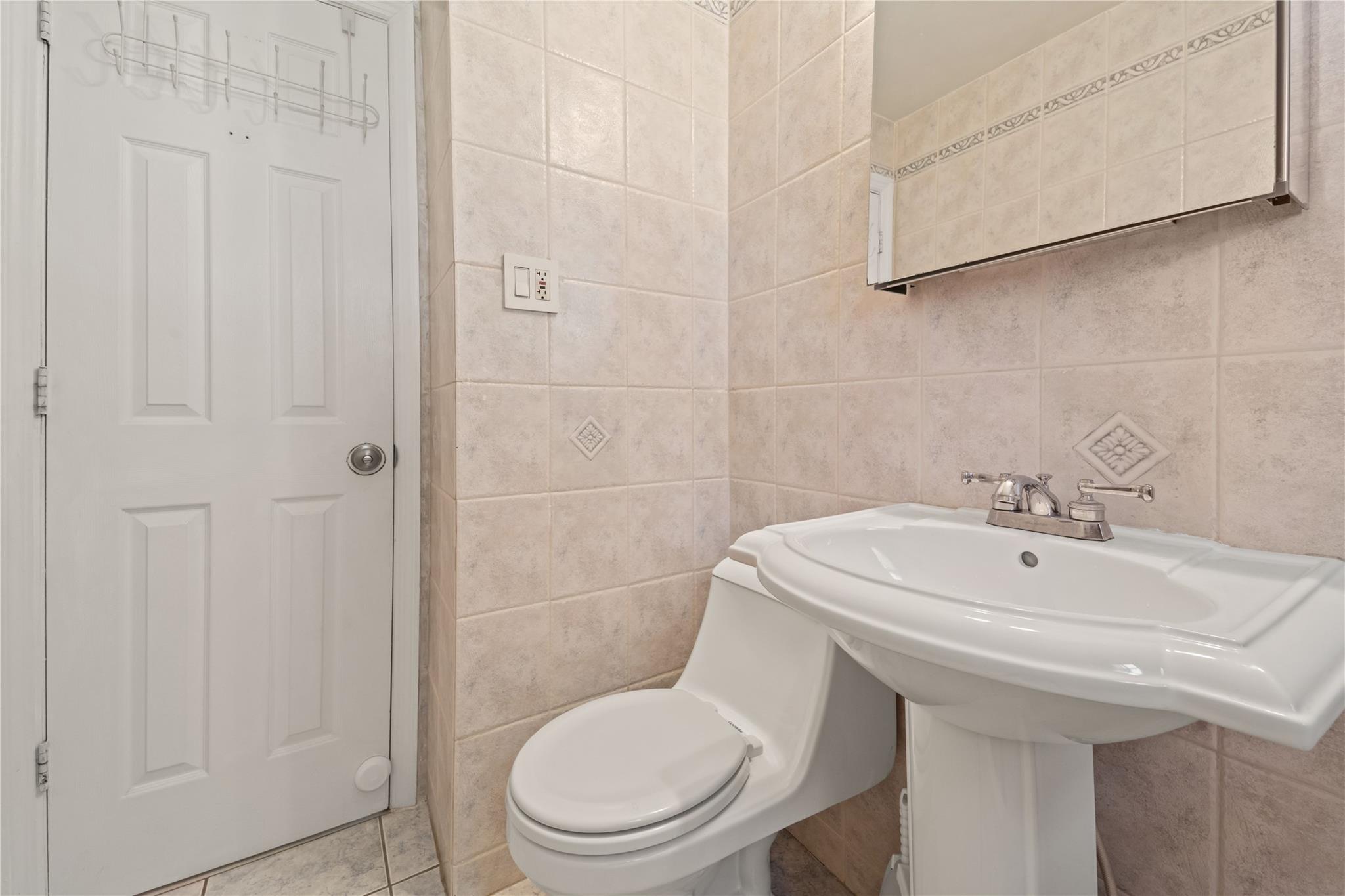 221-03 67th Avenue, Unit 1 Queens, NY 11364 - Photo 13 of 14 a bathroom with a sink a toilet and a mirror