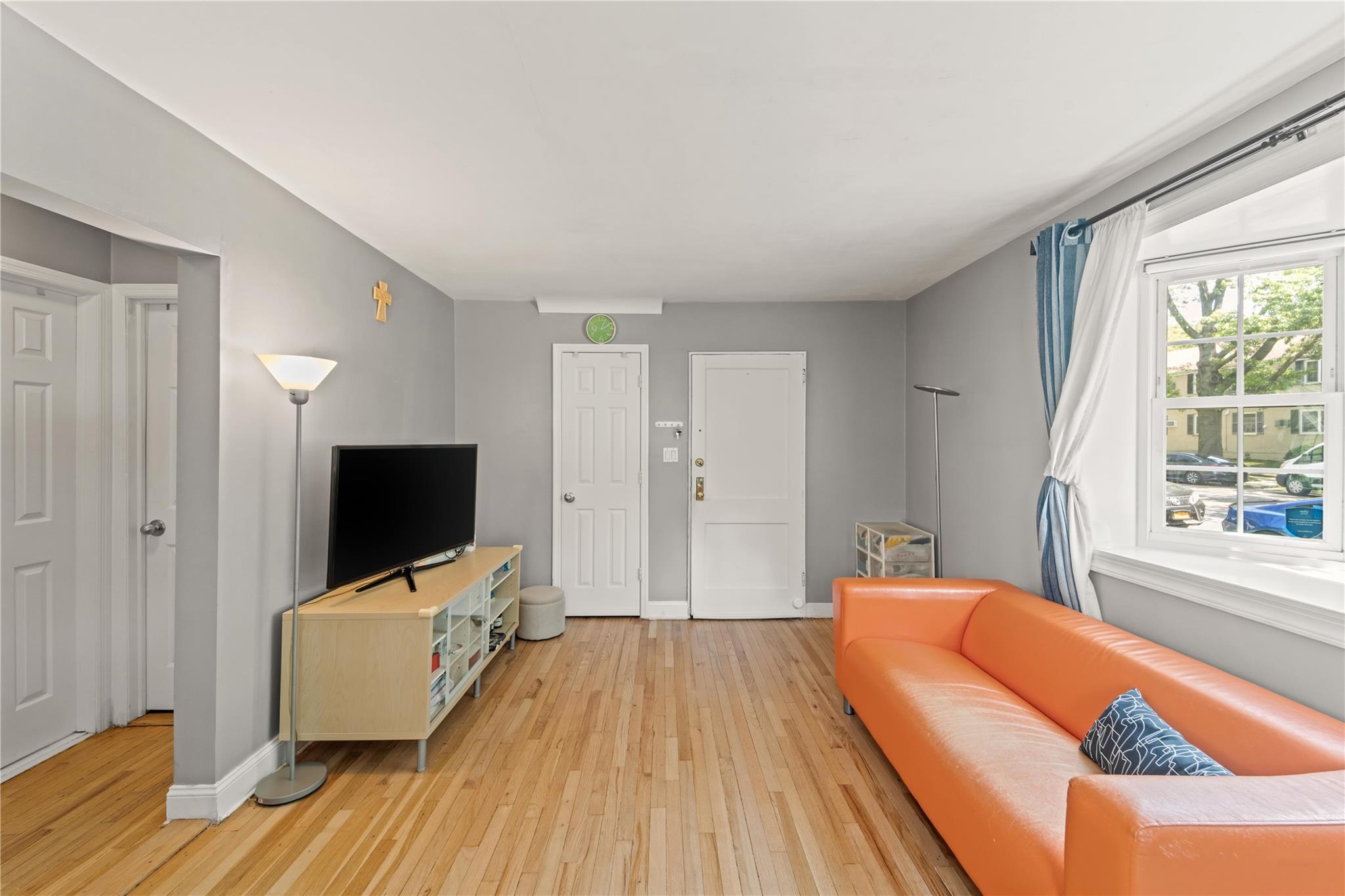 221-03 67th Avenue, Unit 1 Queens, NY 11364 - Photo 3 of 14 a bedroom with a bed and a flat screen tv