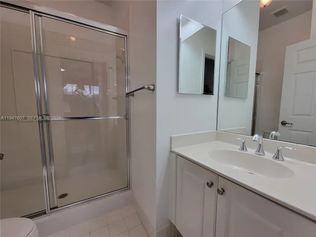 a bathroom with a shower sink and mirror