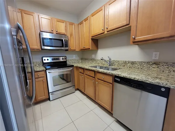 a kitchen with stainless steel appliances granite countertop a sink stove and microwave