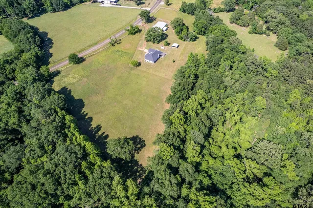 a front view of a house with a garden and yard