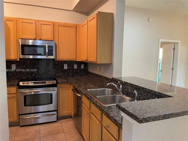 a kitchen with stainless steel appliances granite countertop a sink stove and microwave