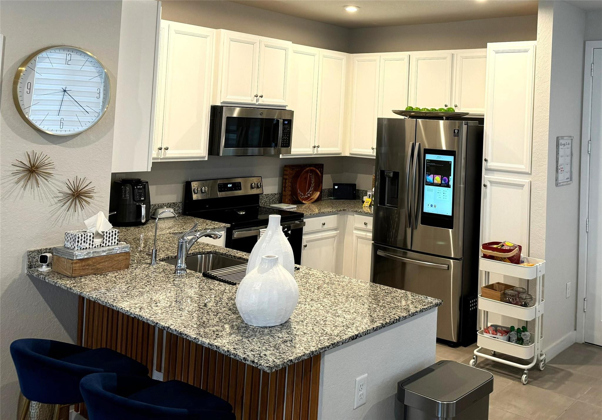 10957 Southwest 232nd Terrace Homestead, FL 33032 - Photo 3 of 11 a kitchen with stainless steel appliances granite countertop a kitchen island a stove a table and chairs