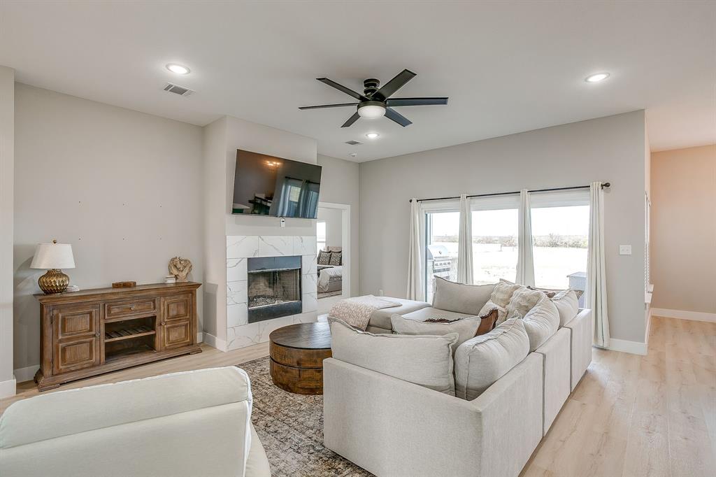 920 Kite Road Mineral Wells, TX 76067 - Photo 7 of 30 a living room with furniture a fireplace and a flat screen tv