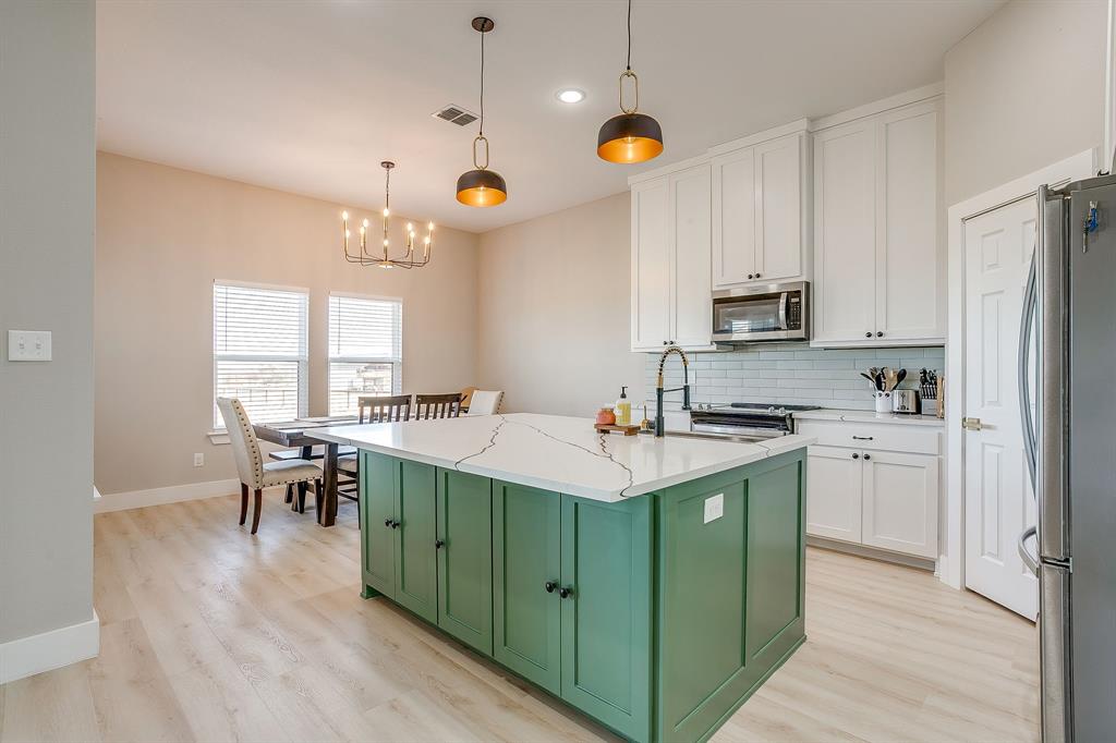 920 Kite Road Mineral Wells, TX 76067 - Photo 10 of 30 a kitchen with kitchen island granite countertop a sink a counter top space appliances and cabinets