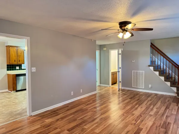 a view of an empty room with window and wooden floor