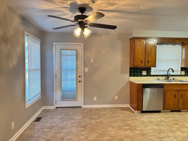 a view of kitchen with granite countertop cabinets and chandelier
