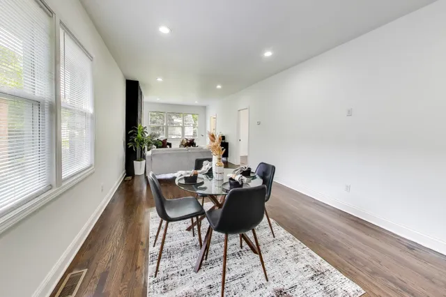 a dining room with a wooden table and chairs