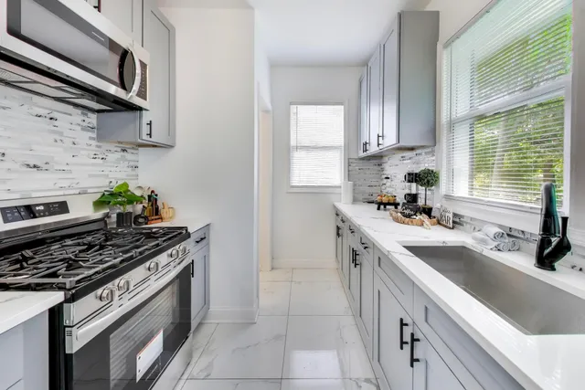 a kitchen with stainless steel appliances a sink stove and cabinets