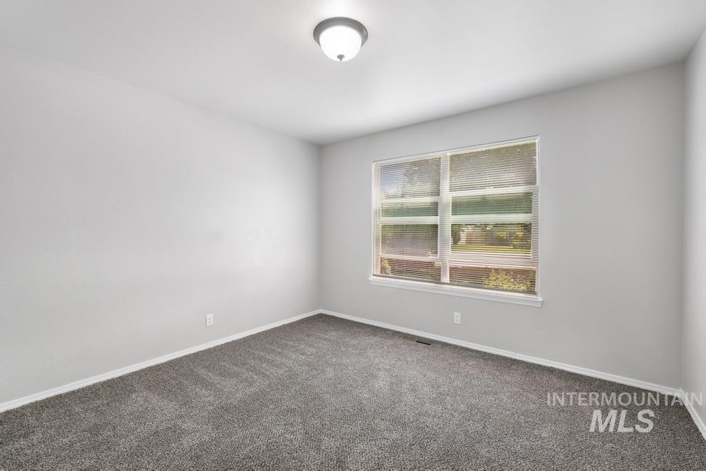 1183 Cortes Loop Twin Falls, ID 83301 - Photo 10 of 30 Spacious room featuring gray wall-to-wall carpeting, light gray wall paint, and a rectangular window with blinds