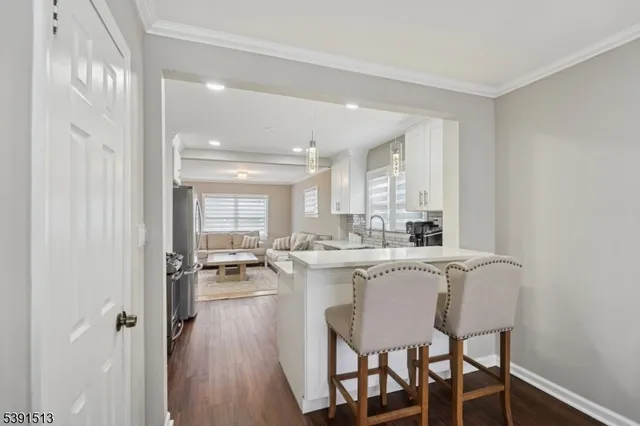 a view of a dining room and livingroom with furniture wooden floor a chandelier