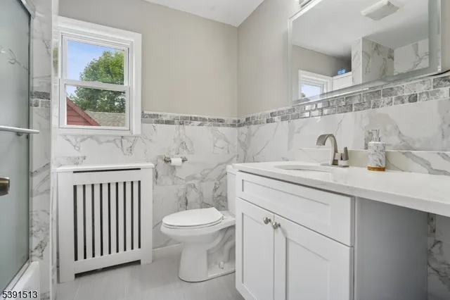 a bathroom with a sink a toilet and a window