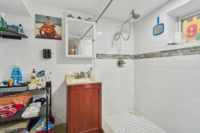 a bathroom with a granite countertop sink a mirror and shower