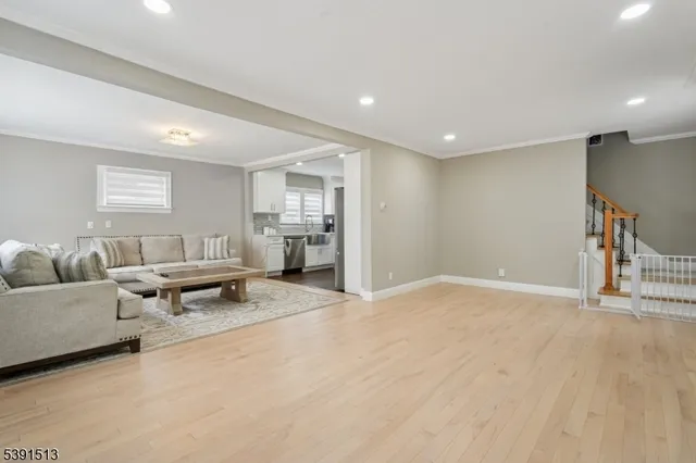 a living room with furniture and a dining table with wooden floor