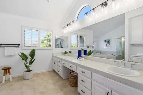 a spacious en suite bathroom with double vanity and a mirror