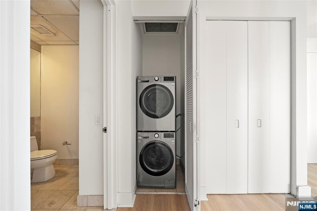 4 Beacon Way, Unit 1407 Jersey City, NJ 07304 - Photo 12 of 19 a view of a hallway with washer and dryer