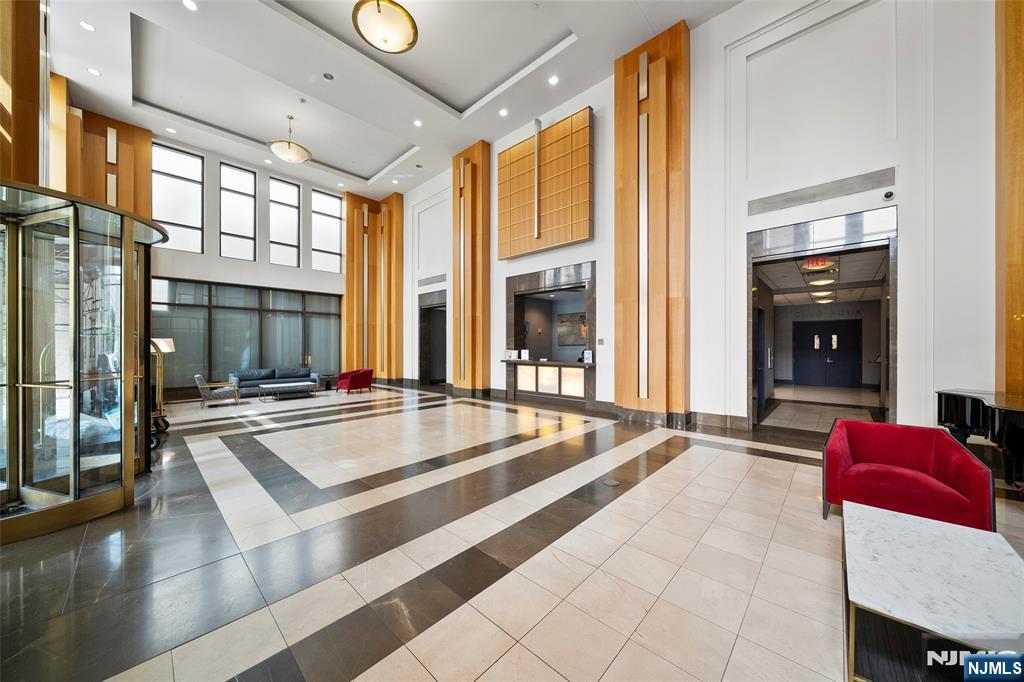4 Beacon Way, Unit 1407 Jersey City, NJ 07304 - Photo 16 of 19 a living room with furniture and large windows