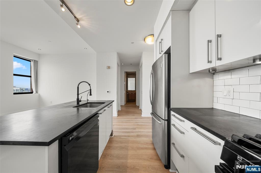 4 Beacon Way, Unit 1407 Jersey City, NJ 07304 - Photo 3 of 19 a kitchen with stainless steel appliances granite countertop a sink and cabinets
