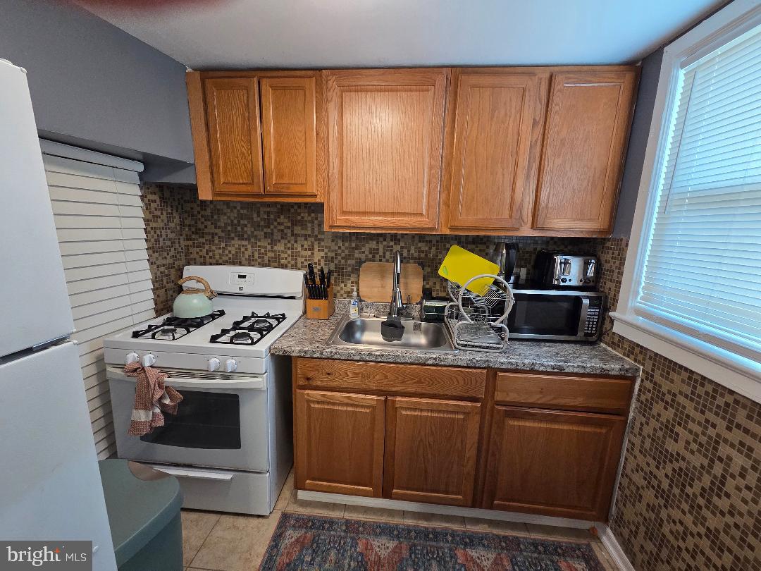 2754 Iverson Street, Unit 72 Temple Hills, MD 20748 - Photo 8 of 17 a kitchen with stainless steel appliances granite countertop a stove a sink and a microwave
