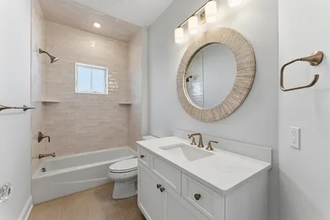 a kitchen with stainless steel appliances a sink a stove a refrigerator and white cabinets