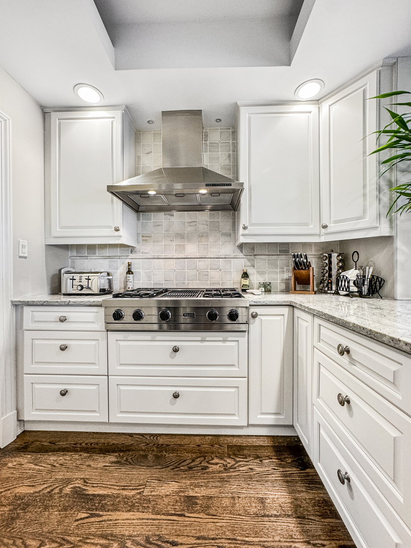 2224 North Wayne Avenue Chicago, IL 60614 - Photo 11 of 36 a kitchen with granite countertop a stove oven and white cabinets