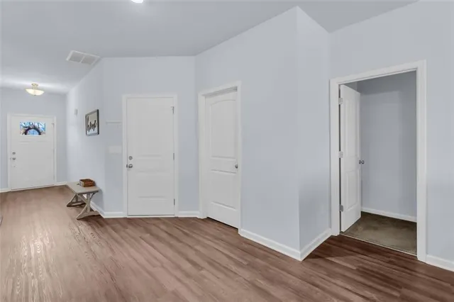 an empty room with wooden floor and closet