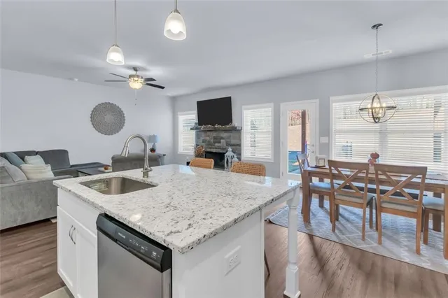 a kitchen with granite countertop a sink a counter top space and living room view