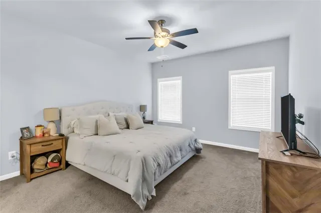 a bedroom with a bed a window and a flat screen television