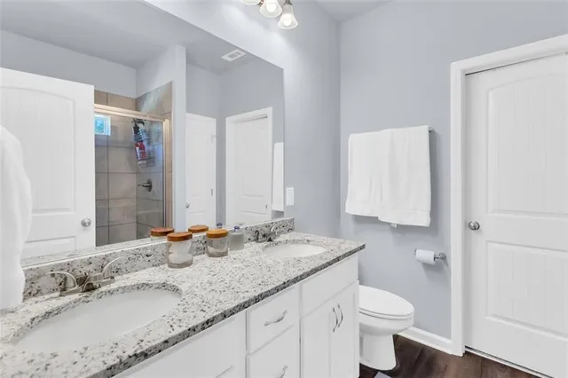 a bathroom with a granite countertop sink a toilet and a mirror
