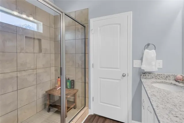a bathroom with a granite countertop shower and a sink