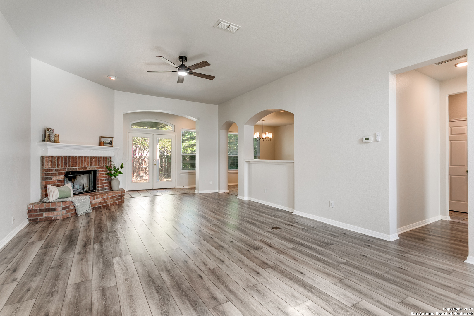 112 Spring Fawn Cibolo, TX 78108 - Photo 4 of 26 an empty room with wooden floor fireplace and windows