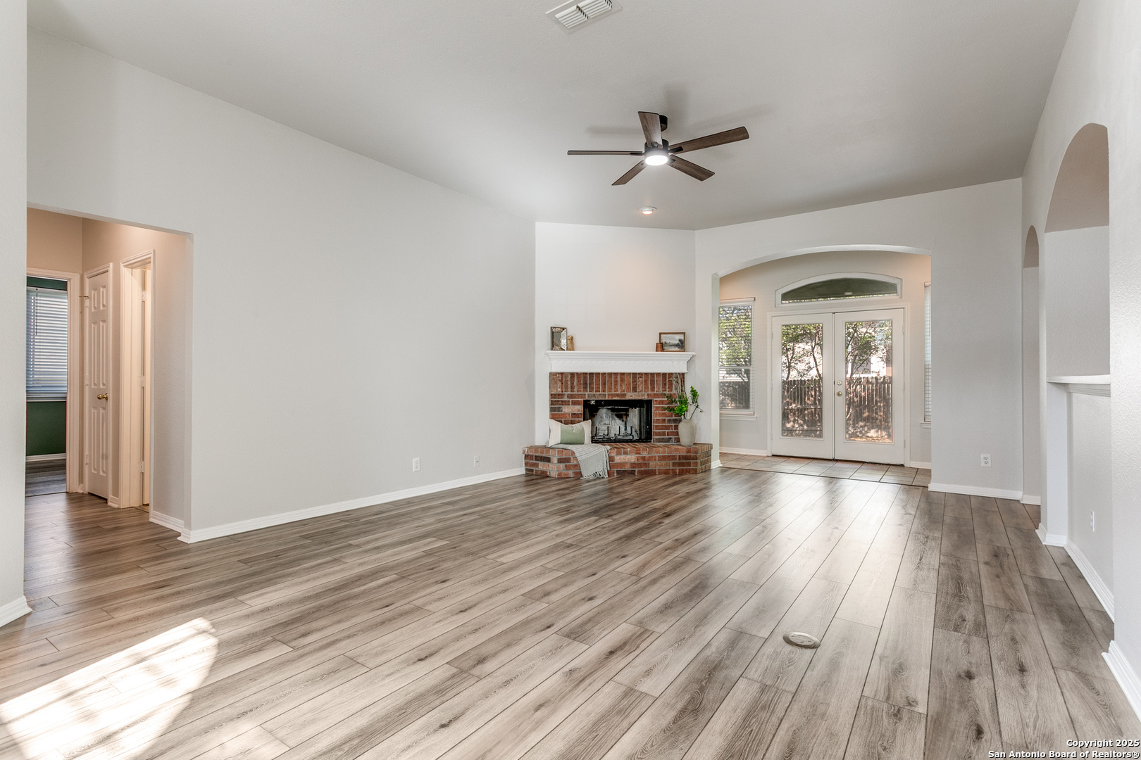 112 Spring Fawn Cibolo, TX 78108 - Photo 5 of 26 a view of a livingroom with wooden floor a ceiling fan and kitchen space with a sink