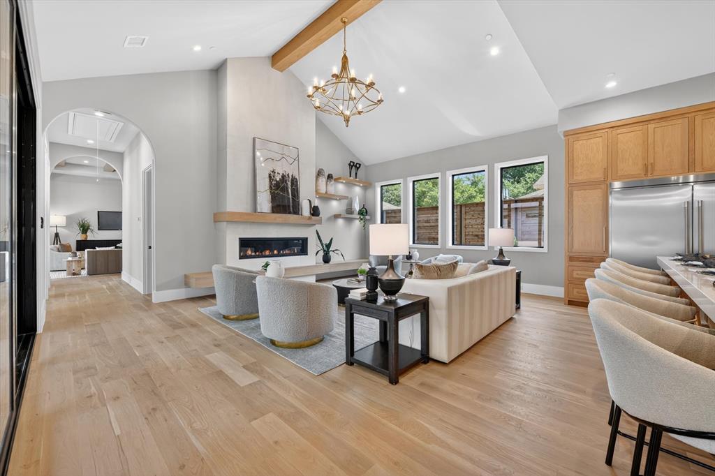 11028 Edgemere Road Dallas, TX 75230 - Photo 19 of 40 Vaulted ceiling with an exposed wood beam, wide plank wood-finish flooring, and a linear fireplace with a wood mantle