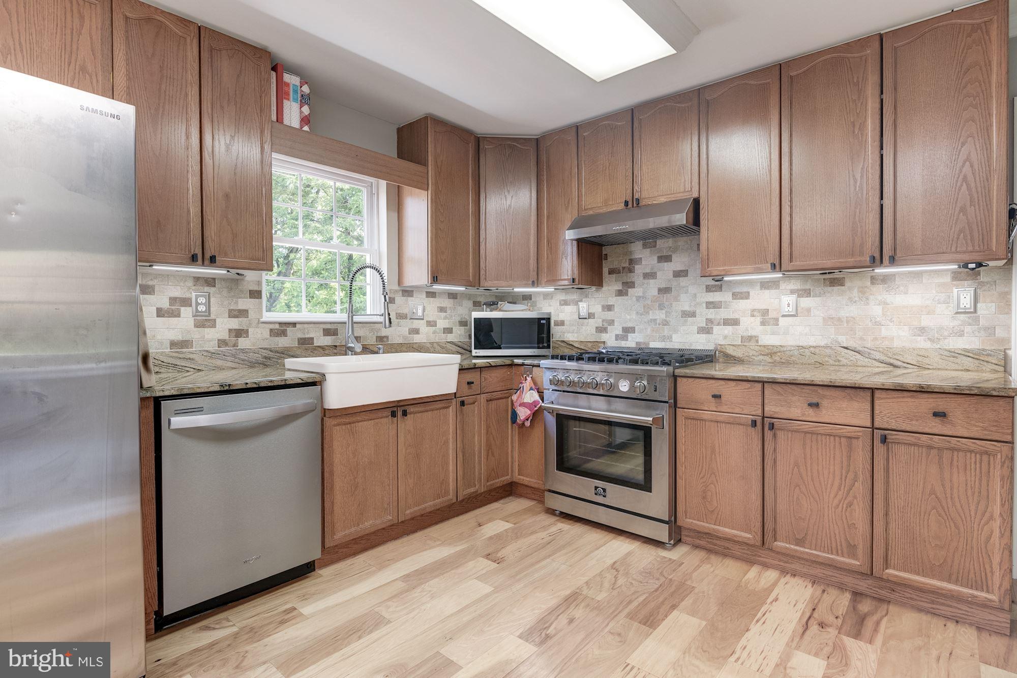 8702 Winands Road Randallstown, MD 21133 - Photo 8 of 32 a kitchen with stainless steel appliances granite countertop a sink stove and refrigerator