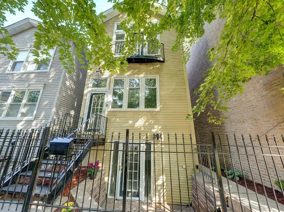 a view of a brick house with a small yard
