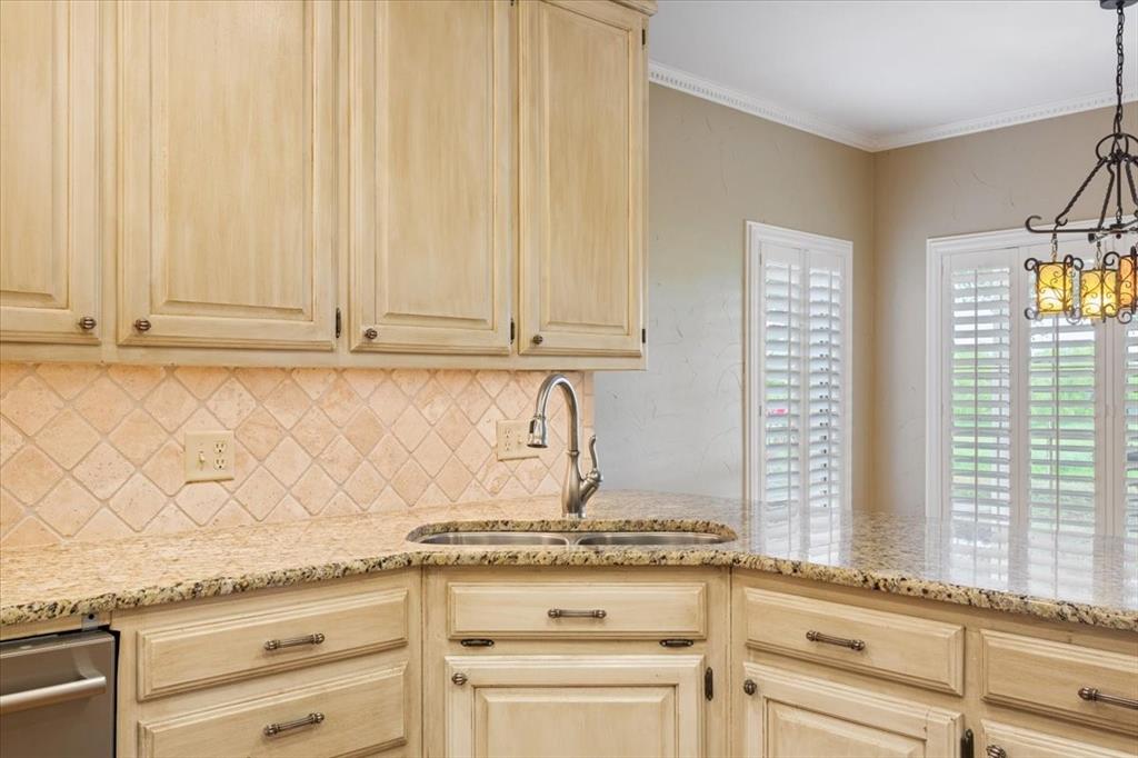 4843 South 3rd St Road Waco, TX 76706 - Photo 14 of 39 Kitchen with light brown cabinets, light stone counters, tasteful backsplash, a sink, and an inviting chandelier