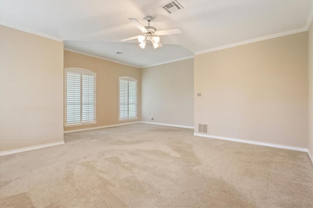 4843 South 3rd St Road Waco, TX 76706 - Photo 18 of 39 Carpeted empty room with visible vents, ceiling fan, and crown molding