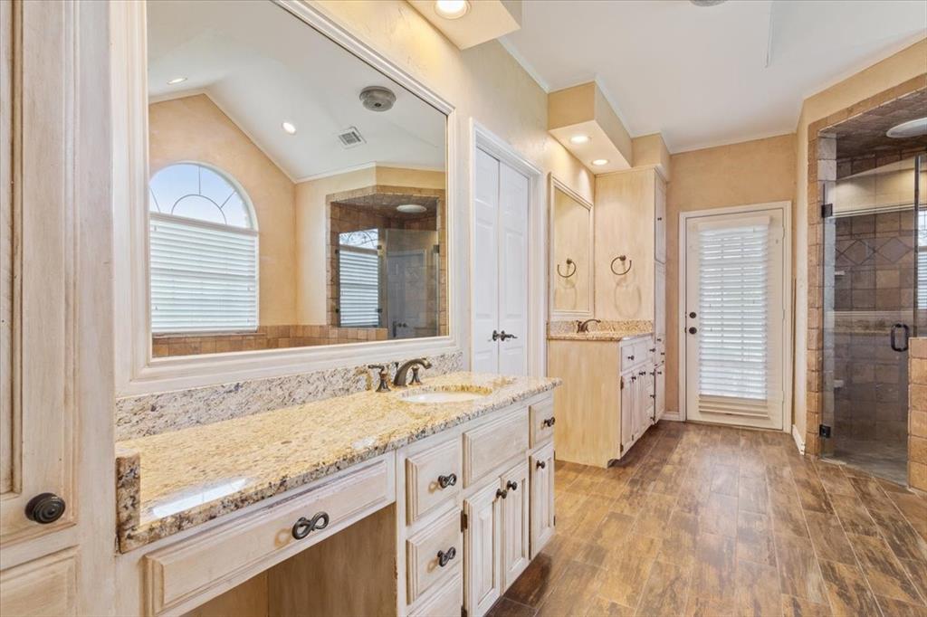 4843 South 3rd St Road Waco, TX 76706 - Photo 21 of 39 Bathroom with wood finished floors, a stall shower, vanity, ornamental molding, and visible vents