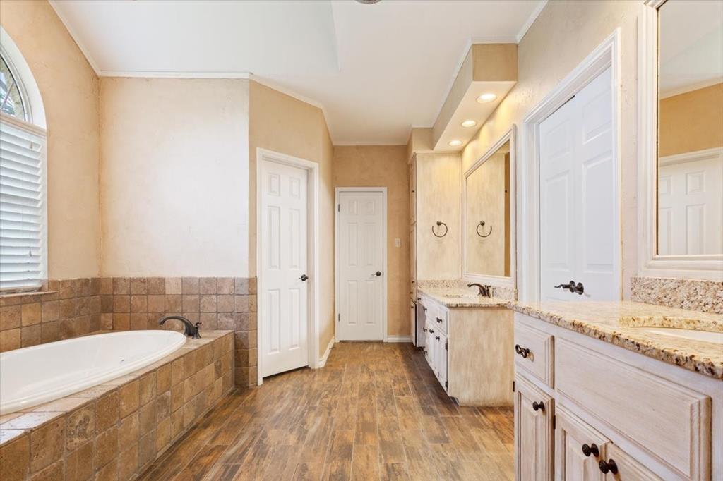 4843 South 3rd St Road Waco, TX 76706 - Photo 22 of 39 Bathroom featuring a garden tub, wood finished floors, a sink, and crown molding