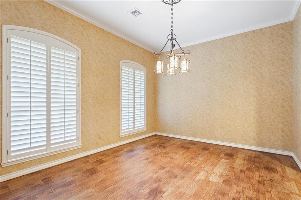 4843 South 3rd St Road Waco, TX 76706 - Photo 7 of 39 Unfurnished room with crown molding, wood finished floors, an inviting chandelier, baseboards, and visible vents