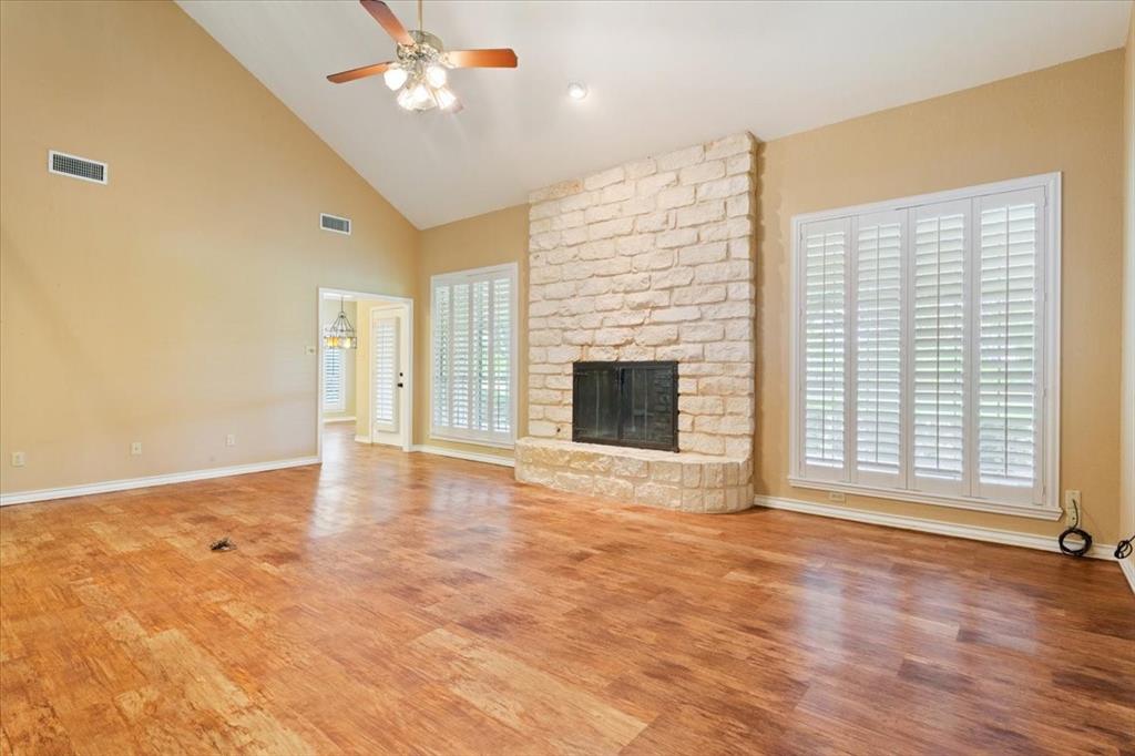 4843 South 3rd St Road Waco, TX 76706 - Photo 10 of 39 Unfurnished living room with wood finished floors, visible vents, ceiling fan, and a healthy amount of sunlight