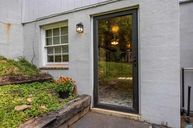 an empty room with wooden floor chandelier fan and windows