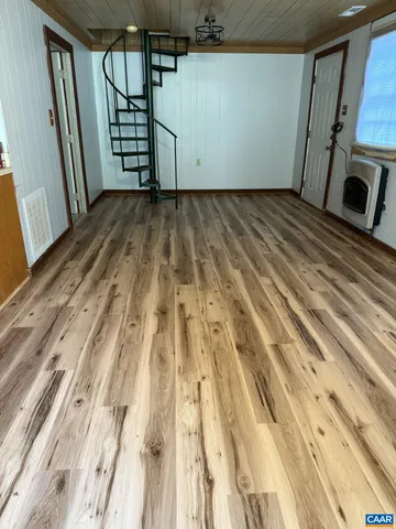 a view of an empty room with closet and a window