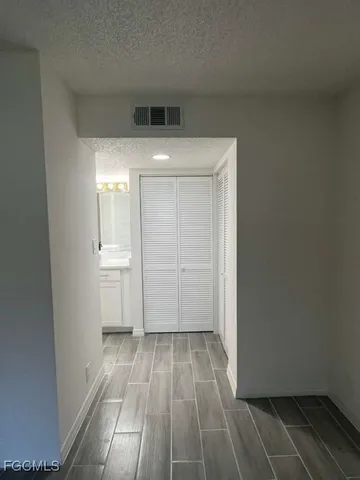 a view of empty room with wooden floor and cabinets