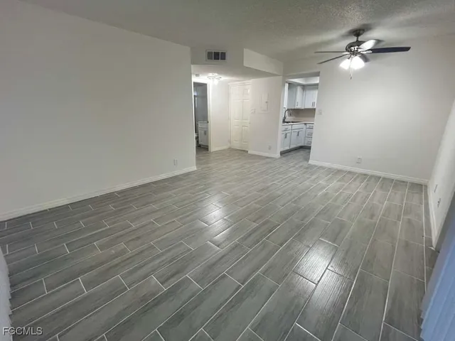 a view of empty room with wooden floor