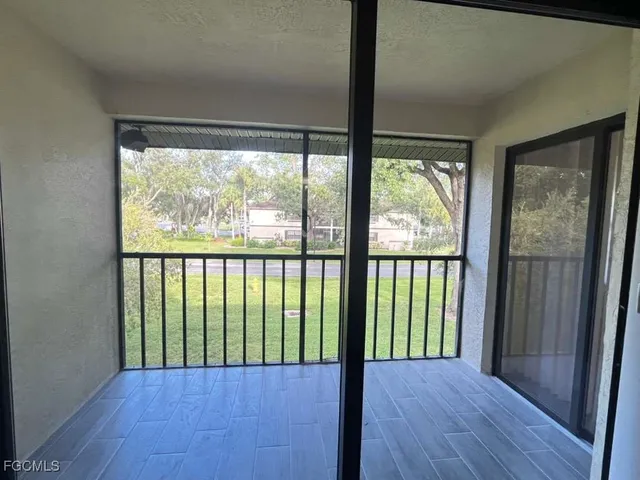 a view of a room with wooden floor and front door