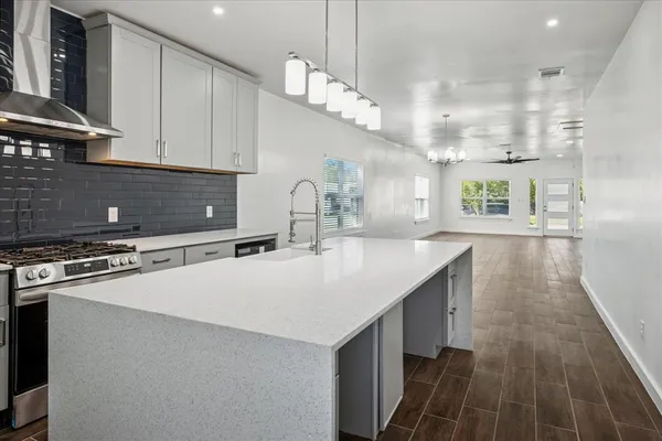 a kitchen with kitchen island granite countertop a stove and a sink