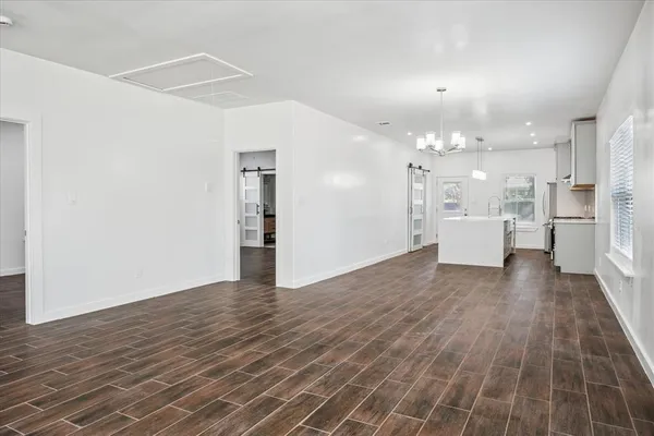 a view of a kitchen with a refrigerator and wooden floor